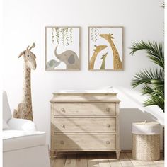 a baby's room with two giraffes on the wall and a dresser