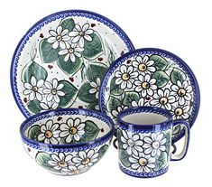 a set of three plates and two cups with flowers painted on the front, sitting next to each other