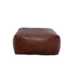 a brown leather ottoman sitting on top of a white floor