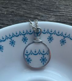 a white plate with a silver ring on it and snowflakes around the edge