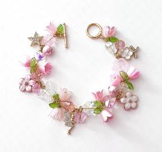 This delicate lily of the valley charm bracelet is handcrafted by myself.  The gold plated chain is 7 3/4 inches long with a toggle clasp.  It contains glass butterflies, a heart,  flowers and lots of crystals so it sparkles as you move.  If you need it shorter or longer just let me know, and I will adjust it to as close as possible to the size you desire.  Each charm is placed with thought  for color and balance.  It is  a really pretty bracelet, and sure to make you smile for years to come. If Lily Of The Valley Bracelet, Crystal Bracelet Ideas, Lily Of The Valley Fairy, Fantasy Objects, Glass Butterflies, Flower Charm Bracelet, Heart Flowers, Diy Jewelry Unique, Clay Craft