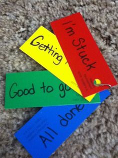 three colorful paper tags with writing on them