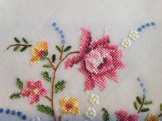 a close up of a piece of cloth with flowers and leaves embroidered on the side