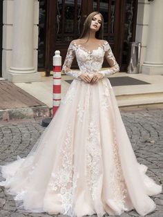 a woman standing in front of a building wearing a wedding dress