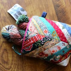 several balls of yarn sitting on top of a wooden table next to a piece of cloth