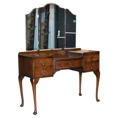 an antique dressing table with mirror and drawers