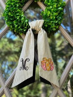 a pair of bows with monogrammed letters are hanging on the front door window