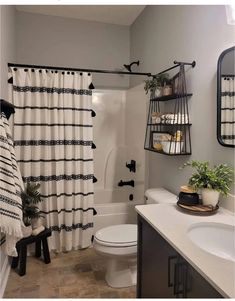 a bathroom with black and white shower curtains