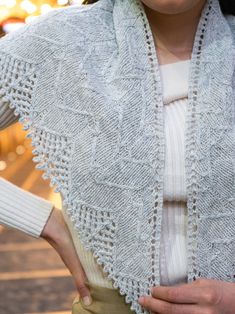 a woman wearing a white knitted shawl