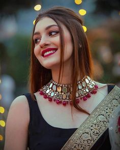 a woman in a black dress wearing a red and gold choker with jewels on it