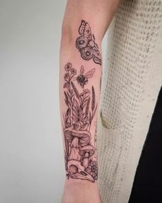 a woman's arm with flowers and butterflies tattooed on the left side of her arm