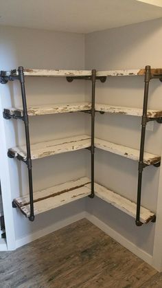 an empty room with shelves and pipes in the corner on either side of the wall