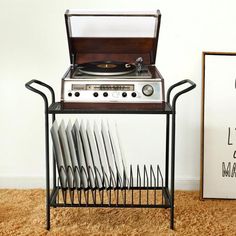 an old record player and some plates on a stand