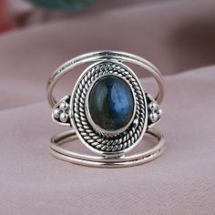 TITLE: -  Natural Labradorite Ring, Sterling Silver Jewelry, Boho Statement Ring, Wired Design Band Ring, Oval Shape Ring, Blue Flashy Gemstone Ring SPECIFICATIONS: - ❖ Metal:  925 Solid sterling silver ❖ Gemstone:  Labradorite ❖ Gemstone Size: 7x9  mm ❖ Total Weight:  5.7Gram ❖ Gemstone Setting: Bezel Note: Our use of natural stones may result in slight variations in texture and color in the actual product you receive, but the quality and grade of the stone remain consistent. FEATURES: -  * This stylish statement ring features a bezel-set oval labradorite on a  Wired Design Band Ring. The oval gemstone is a spectacle of shifting hues, reminiscent of the aurora borealis. The flanking 925 sterling silver clusters of metal ropes add texture and detailing to this labradorite solitaire ring. Adjustable Oval Spiritual Rings, Spiritual Oval Stackable Moonstone Ring, Spiritual Oval Moonstone Stackable Ring, Adjustable Oval Sapphire Ring, Oval Stackable Bohemian Jewelry, Bohemian Oval Stackable Jewelry, Bohemian Oval Stackable Rings, Oval Labradorite Promise Rings, Adjustable Oval Gemstone Stackable Rings