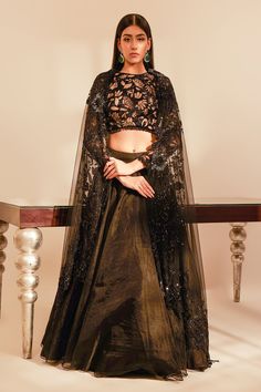 Black full sleeves padded blouse with sequin, thread, cutdana embroidery in a floral pattern and crystal drops on the waist. Paired with solid organza lehenga with attached cancan and border embroidered sheer dupatta.
Component: 3
Pattern: Embroidery
Type Of Work: Sequin, thread, cutdana, crystal
Neckline: Round
Sleeve Type: Full
Fabric: Tulle, Organza
Color: Black
Other Details: 
Lehenga Length : 44 inches
Attached double lining
Blouse with crystal drops on the waist and sleeve hems
Sheer dupat Party Choli With Intricate Embroidery In Raw Silk, Floor-length Evening Choli With Resham Embroidery, Floor-length Choli With Resham Embroidery For Evening, Party Blouse Piece For Eid With Intricate Embroidery, Eid Party Blouse Piece With Intricate Embroidery, Evening Party Wear Anarkali Set With Resham Embroidery, Evening Anarkali Set With Resham Embroidery, Evening Gown With Resham Embroidery For Diwali, Party Wear Blouse With Intricate Embroidery For Reception