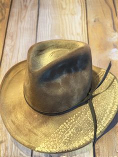 This unique vintage fedora hat, crafted from Australian wool, features an eye-catching design that includes a braided rope band and an embossed crocodile pattern on the brim. The hat is marked with the Woolmark logo inside, indicating it is made of pure new wool. The exterior showcases a worn, rustic charm, characteristic of a well-loved hat with a rich history. The brim's distinctive crocodile pattern adds a touch of rugged elegance, making this hat a standout piece for collectors and fashion enthusiasts alike. It appears to be from the mid-20th century, a time when such bold designs were popular in outdoor and casual attire. **Condition The hat shows signs of wear consistent with its age, including some fading and minor creases, which only enhance its vintage appeal. The interior is clea Western Style Gold Fedora With Flat Brim, Western Gold Fedora With Short Brim, Western Style Gold Fedora With Short Brim, Vintage Flat Brim Fedora For Outdoor, Adjustable Brimmed Gold Fedora, Adjustable Gold Brimmed Fedora, Gold Wide Brim Fedora For Festivals, Adjustable Rustic Fedora, Adjustable Gold Wide Brim Fedora