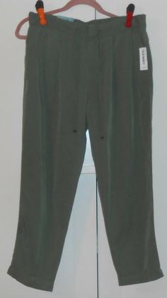 PLEASE NOTE:  IF YOU SEE A DISCOLORATION ON THE PANTS IT'S FROM THE FLASH OF THE CAMERA I GUARANTEE THE PANTS IN A-ONE CONDITION!!!! WOMEN'S OLD NAVY OLIVE GREEN MID-RISE PLEATED SOFT PANTS - SIZE 14 - BANDED WAIST IN FRONT WITH TWILL TAPE DRAWSTRING - WIDE ELASTICIZED WAIST IN BACK - ZIP-FLY - DOUBLE HOOK AND BAR CLOSURE WITH INTERIOR BUTTON - PLEATED DETAIL AT FRONT - SLANT POCKETS IN FRONT - FAUX WELT POCKETS IN BACK - SOFT MEDIUM-WEIGHT TENCEL RAYON BLENDED FABRIC - MID-RISE SITS BELOW WAIST Olive Pants For Summer Workwear, Olive Tapered Leg Pants For Spring, Olive Relaxed Fit Pants For Summer, Spring Olive Tapered Leg Pants, Trendy Olive Pants For Spring, Fitted Olive Pants For Spring, Casual Bottoms For Spring, New With Tags, Soft Pants, The Flash