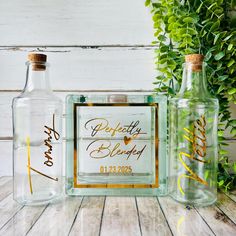 two glass bottles with gold lettering on them