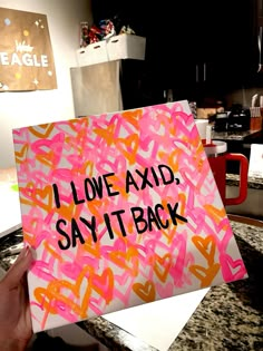 someone is holding up a sign that says i love axd, say it back