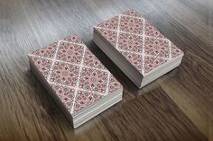 two pink and white cards sitting on top of a wooden table