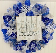 a blue and white wreath with the words let it snow