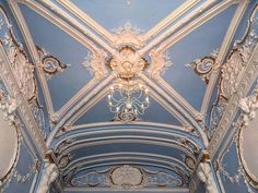 an ornately decorated room with blue walls and white trimmings on the ceiling