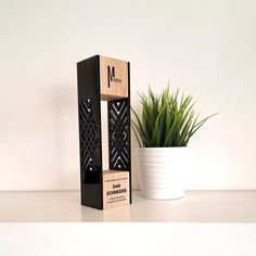 a potted plant sitting next to a wooden block with the word m on it