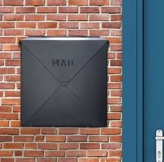 an email box mounted to the side of a brick wall next to a blue door