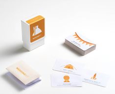 an orange and white business card sitting on top of a table next to some cards