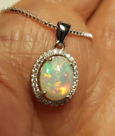 Very Pretty Natural Opal Halo Necklace, Dainty, But Colorful, 8x10mm Ethiopian Opal, See Fire On Video! We Have More Than One, Stones Vary Slightly, Quality Does Not. You May Ask To See Before Purchase. 925 Sterling Silver Pendant, Rhodium Plated, Crystal Halo, 18" Sterling Silver Chain. Gift Box Included. Great Gift! Sterling Silver Necklace With Bail As A Gift, Sterling Silver Necklace With Bail For Anniversary, Silver Oval Necklace With Bail, Oval White Necklace Stamped 925, Halo Necklace, Halo Pendant, Necklace Dainty, Natural Opal, Ethiopian Opal