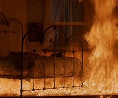 a fire is burning in a bedroom next to a bed