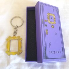 a purple box with a keychain in it next to a yellow and black frame