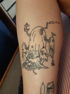 a person with a tattoo on their leg that has an image of a building and other things in it