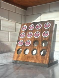 a wooden board with six holes in it on a counter next to a tile wall