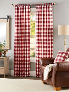 a red and white checkered curtain hangs in front of a window with a brown leather chair