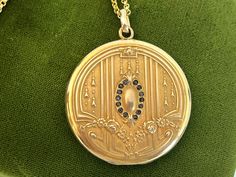 "Description: A large and lovely antique round Art Nouveau monogrammed gold filled photo locket on a new 14K gold filled chain.  The front of this locket made by the SB Company, features a central raised oval shape surrounded by a total of 14 \"paste\" stones. The stones that were probably once clear have darkened with age. There are 7 in paste gems on each side of the central oval. At the top and at the bottom of this oval shape is a raised fleur de lis. There are a total of 6 raised vertical l Antique Medallion Locket Necklace Stamped 14k, Antique Gold Locket Necklace Stamped 14k, Victorian Round Locket Necklace Stamped 14k, Formal Yellow Gold Filigree Locket Necklace, Formal Yellow Gold Locket Necklace With Intricate Design, Ornate Yellow Gold Hallmarked Locket Necklace, Victorian Yellow Gold Locket Necklace For Formal Occasions, Art Deco Round Necklace For Anniversary, Elegant Ceremonial Coin Jewelry