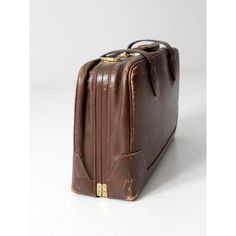 This is a vintage brown leather suitcase.  Beautiful brown leather case with belted strap closures with large brass buckles. a leather handle, brass feet, and number code lock entry.  Interior has a lovely section dividers with linen like lining.   Classic designed luggage piece for display or use. Vintage Business Cases With Leather Lining, Vintage Formal Briefcase With Luggage Sleeve, Vintage Rectangular Briefcase For Business Trips, Vintage Leather Cases For Business Trips, Vintage Leather Case For Business Trips, Vintage Brown Briefcase For Business, Vintage Rectangular Cases For Business Trips, Vintage Rectangular Briefcase For Formal Occasions, Vintage Rectangular Briefcase For Formal Use