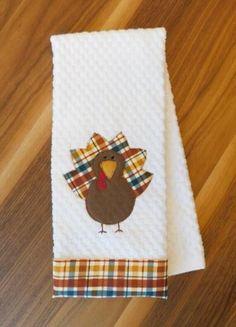 a towel with a turkey on it sitting on top of a wooden floor next to a table