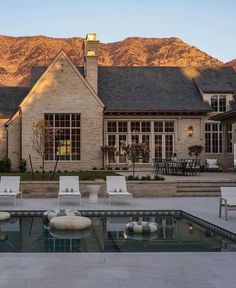 a house with a swimming pool in front of it and mountains in the back ground