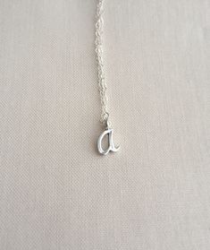 "Cursive initial necklace in sterling silver All items come in a cute jewelry box, ready for gifting. ► D E T A I L S Sterling silver chain + initial Initial | approx. 10-12mm in height depending on the letter. ► H O W TO O R D E R Please choose Length and Initial in the drop down menu options. ► G I F T I NG If you're sending an order directly to a loved one, I can add a sweet little note. Just leave it in the note section box upon checkout. ► P R O D U C T I O N + P R O C E S S T I M E My curr Tiny Silver Necklaces For Mother's Day, Tiny Silver Necklace For Mother's Day, Tiny Initial Pendant Charm Necklace For Gifts, Silver Dainty Initial Necklace For Gift, Silver Dainty Initial Necklace As Gift, Dainty Silver Necklaces With Initials, Delicate Silver Charm Necklaces For Gift, Delicate Silver Charm Necklaces For Bridesmaids, Sterling Silver Initial Necklace With Name