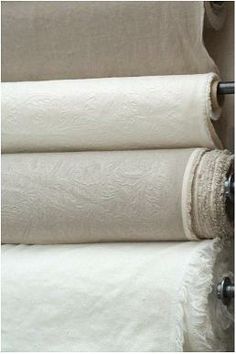 four rolls of white linen are stacked on top of each other