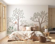 a bedroom with white walls and trees painted on the wall, along with wooden flooring