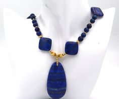 Lapis Lazuli beaded necklace.  Handmade gemstone necklace with gold beads.  Vivid blue lapis necklace with pendant. Lapis Lazuli is an alternative birthstone for September.  Anniversary, birthday and graduation jewelry.  An ideal gift for her.  MATERIALS AND SIZE 9mm round lapis lazuli beads 21x21mm square lapis lazuli beads 7mm, 5mm, 3mm and 2mm round gold filled beads 6mm gold filled jump rings gold filled lobster claw clasp The necklace is 19.5 inches long The pendant adds another 2.25 inches Lapis Lazuli Beaded Necklaces For Gift, Lapis Lazuli Round Beads Necklace For Gift, Lapis Lazuli Gemstone Beads Necklace For Gift, Single Strand Lapis Lazuli Beaded Necklace As Gift, Lapis Lazuli Pendant Beaded Necklace As Gift, Lapis Lazuli Pendant Beaded Necklace For Gifts, Handmade Elegant Lapis Lazuli Beaded Necklaces, Elegant Handmade Lapis Lazuli Crystal Necklaces, Elegant Handmade Lapis Lazuli Crystal Necklace