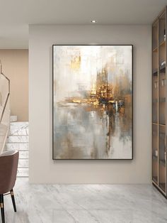 an abstract painting hangs on the wall above a dining room table with chairs and a bookcase