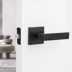 a door handle on the side of a white door in a room with chairs and rugs