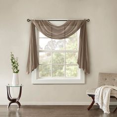 a living room with a couch, chair and window covered in green curtained drapes