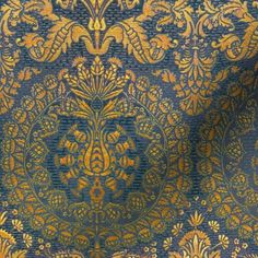 a blue and gold wallpaper with an ornate design on it's side,