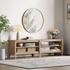 a living room scene with focus on the entertainment center and round mirror over the tv