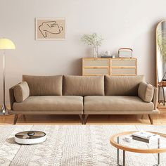 a living room with a couch, coffee table and mirror on the wall next to it