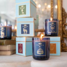 three candles sitting next to each other in front of some boxes on a counter top